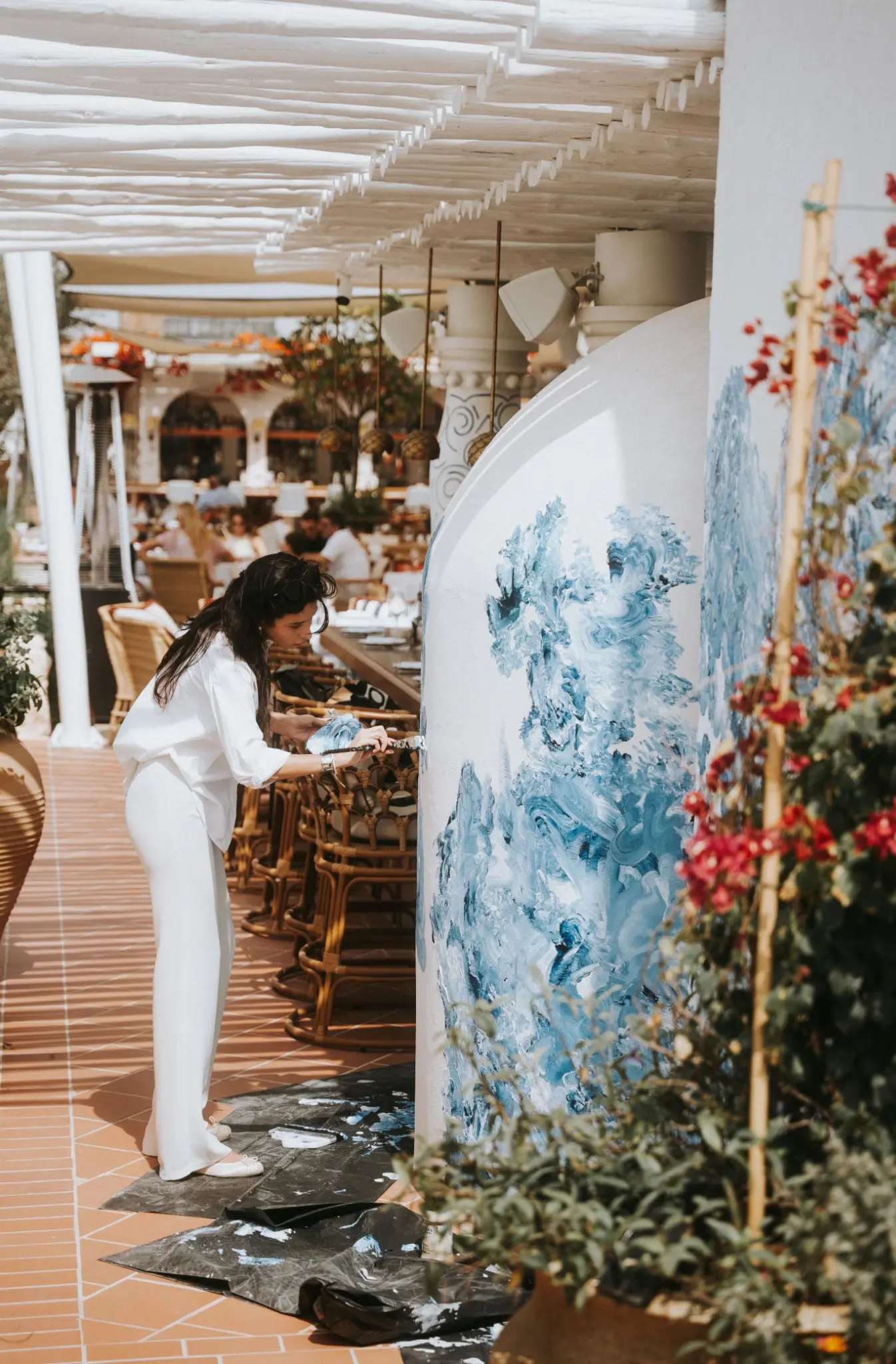 Tina Gavasheli painting a blue installation at Gaia, Dubai.